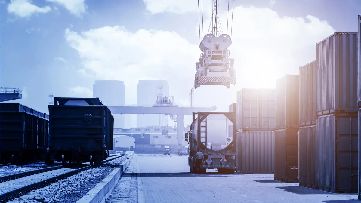 Container vessel alongside a port with the FLG Shipping & Logistics logo