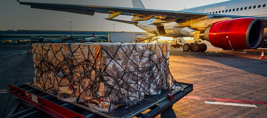 Palletised air cargo being loaded beside an aircraft